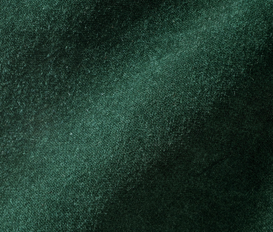 Gros plan d'un pantalon en velours vert foncé.