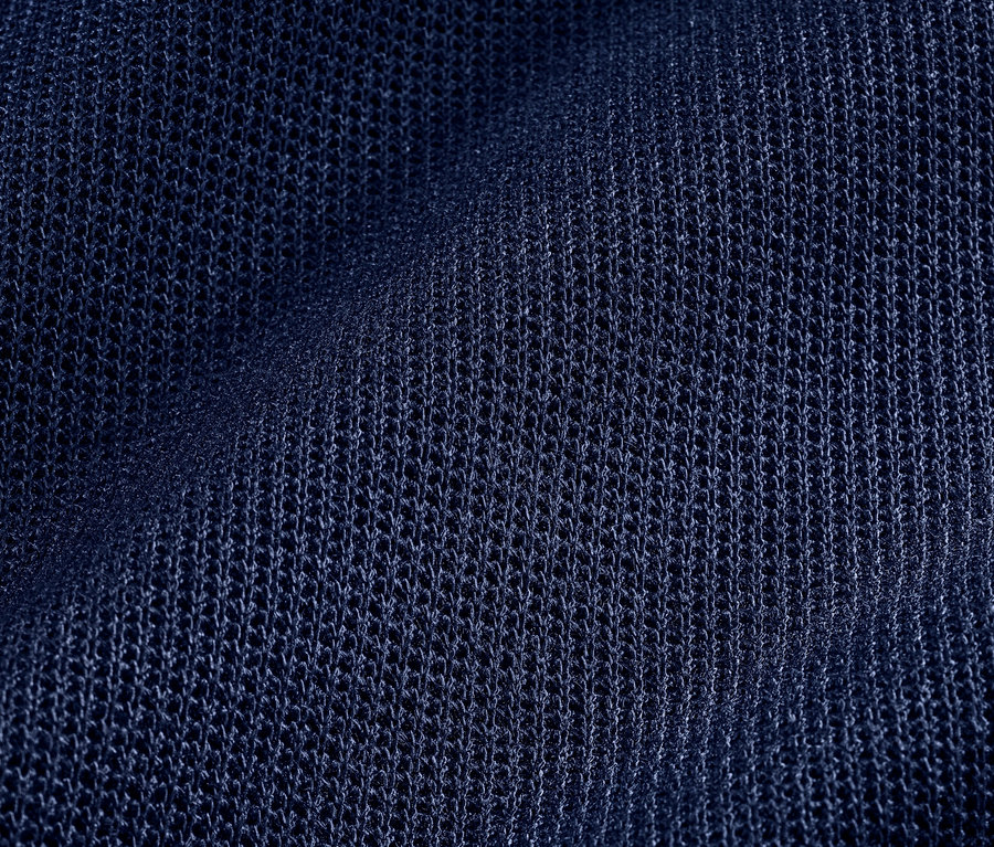 Gros plan sur le tissu texturé bleu foncé d'une blouse.
