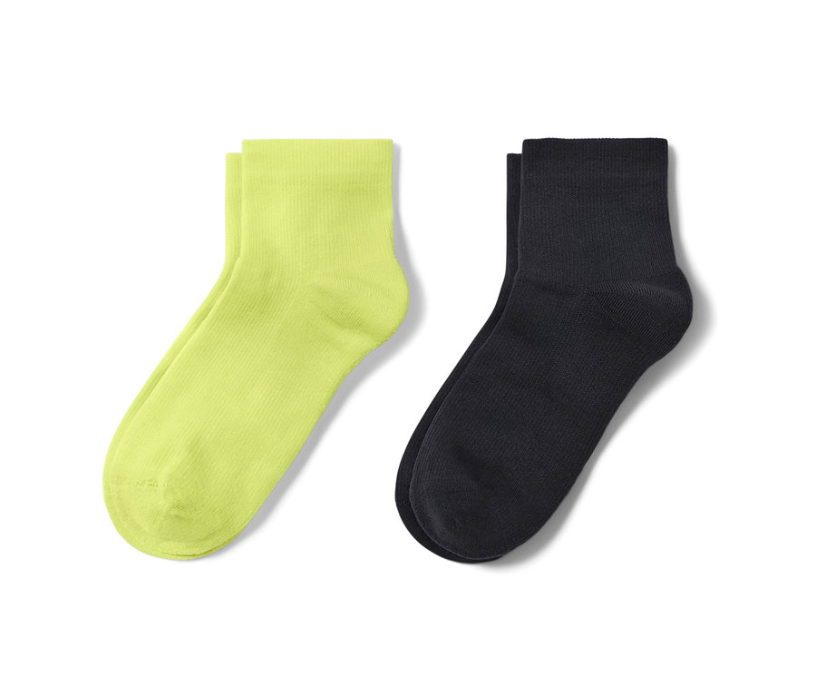 Deux paires de chaussettes de sport courtes, une paire jaune néon, une paire noire.