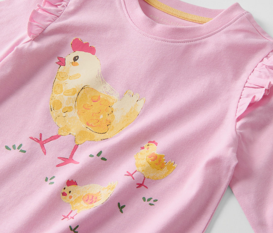 Gros plan sur un t-shirt à manches longues pour enfant avec un motif de poule.