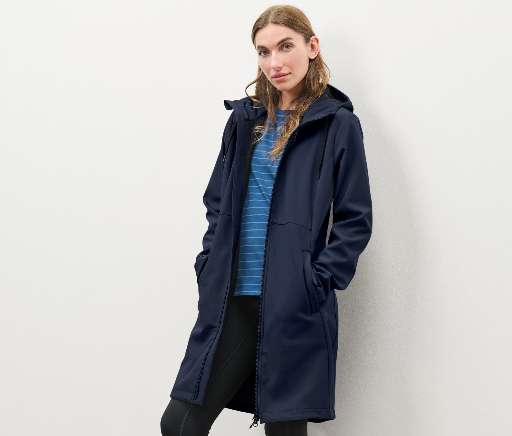 Femme posant dans un manteau softshell bleu.