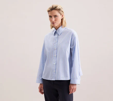 Femme portant une chemise oversize Seidensticker à rayures bleues.