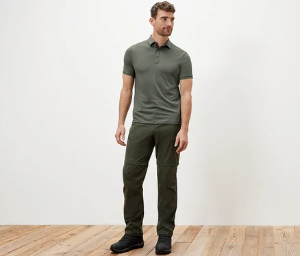 Un homme debout portant un polo fonctionnel kaki.