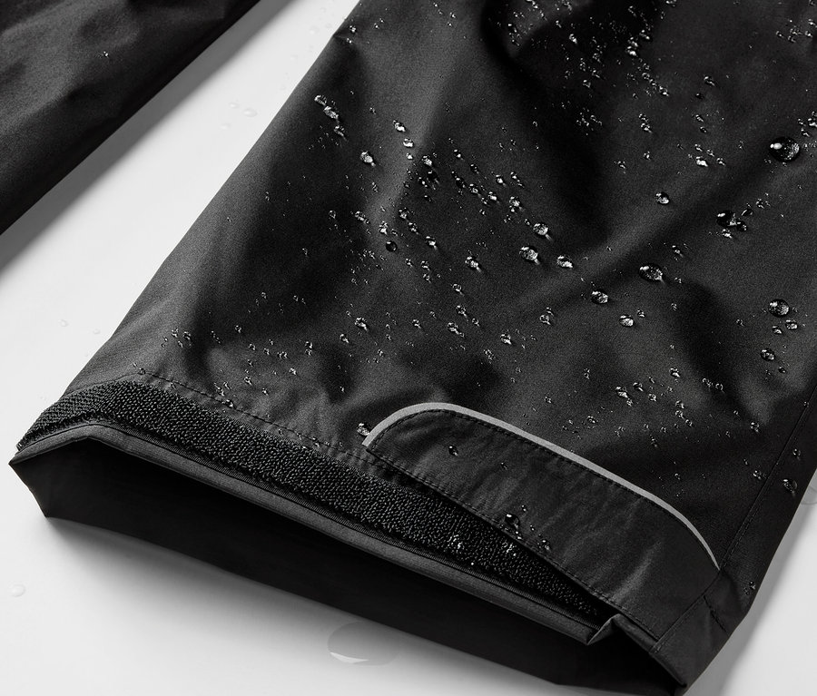 Gros plan sur un pantalon de pluie noir avec des gouttes d'eau.