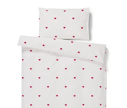 Linge de lit blanc avec des coeurs rouges.
