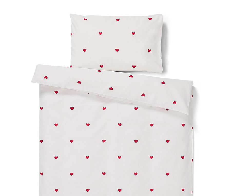 Linge de lit blanc avec des coeurs rouges.