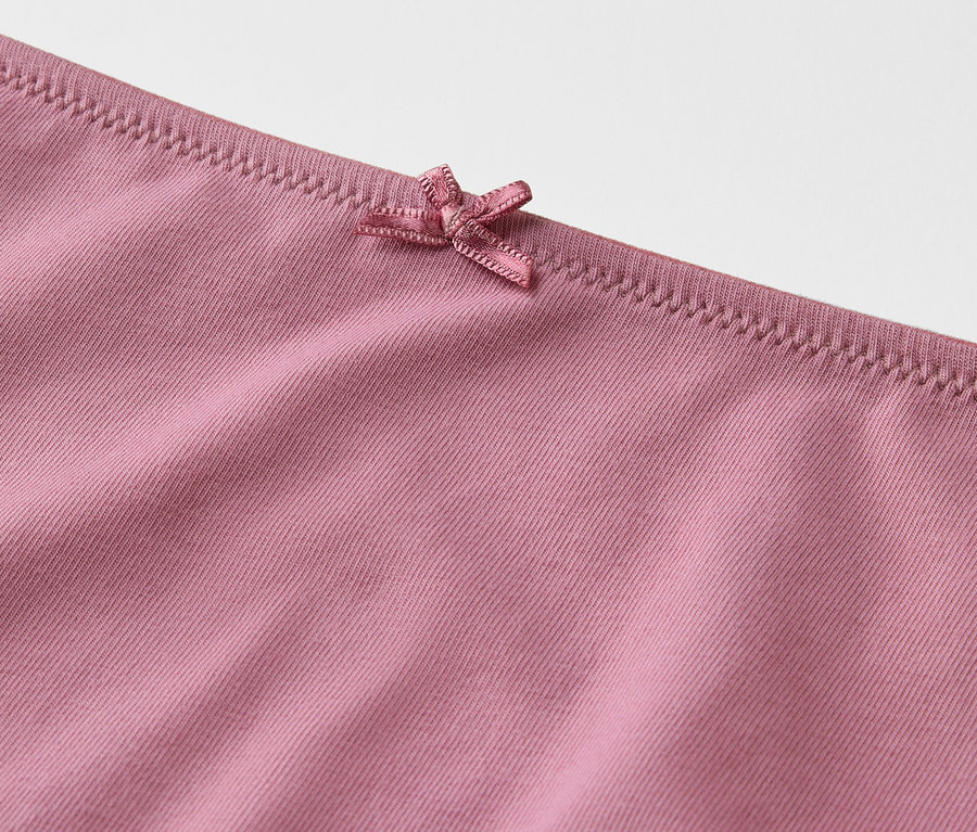 Détail d'une culotte rose avec un nœud.