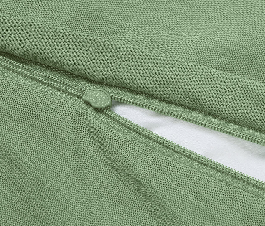 Gros plan d'une taie d'oreiller verte avec fermeture éclair.