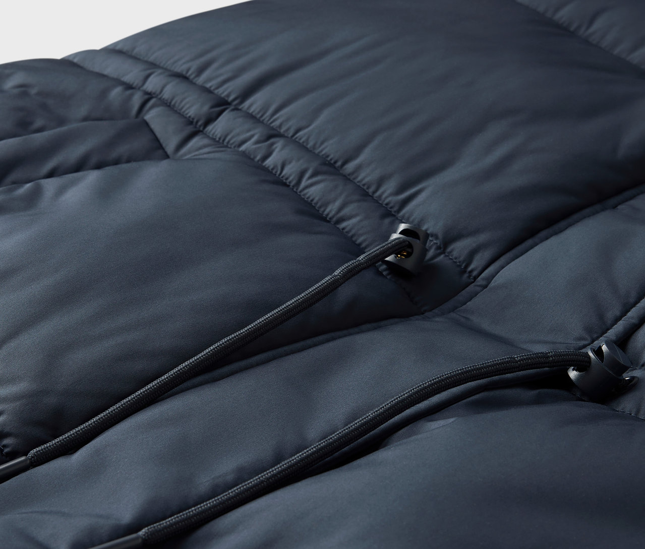 Gros plan sur une doudoune bleu marine avec cordon de serrage.