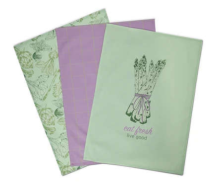 Trois torchons : vert clair avec des artichauts et des betteraves, violet quadrillé et vert clair avec des asperges.