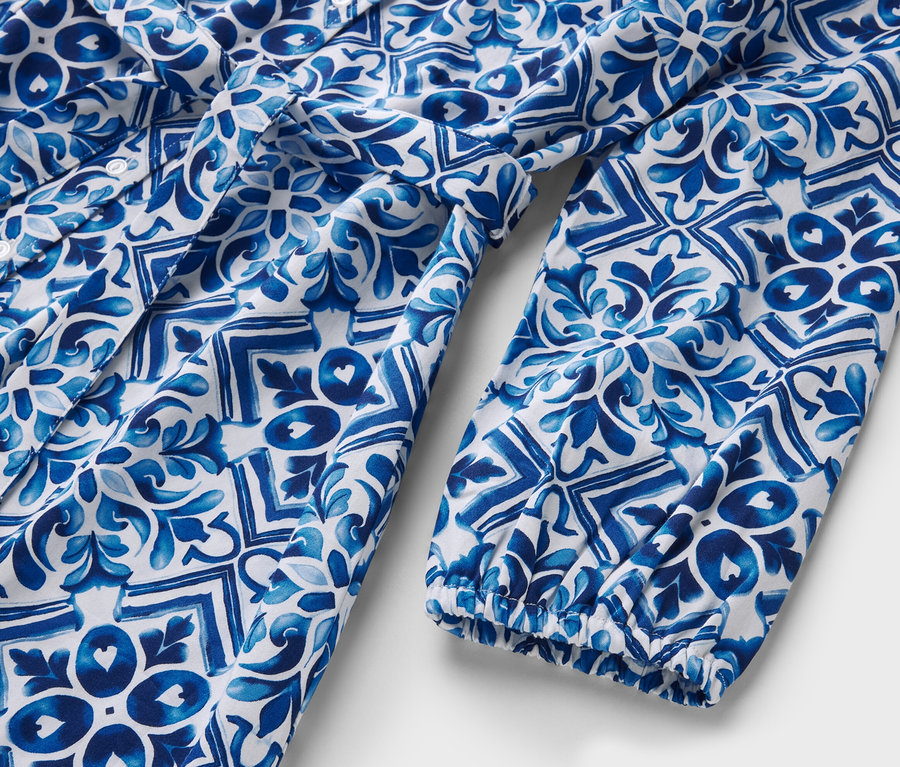 Gros plan sur une robe mi-longue imprimée bleue et blanche.
