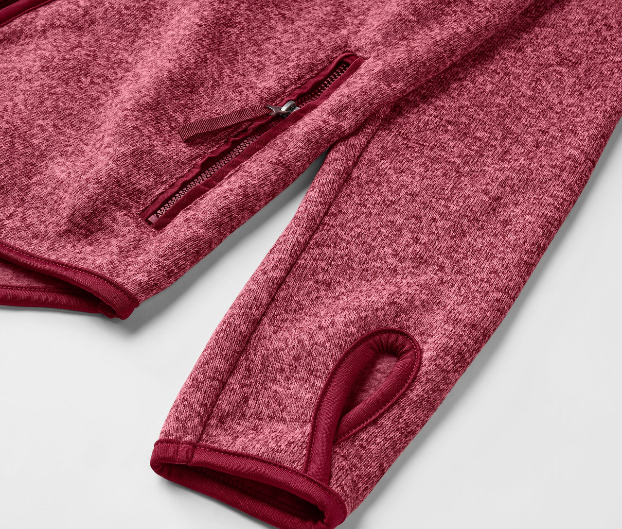 Détail d'une veste en maille polaire rose.