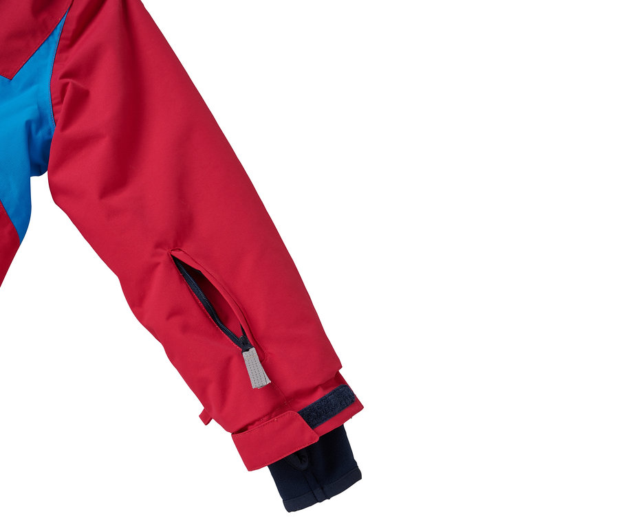 Détail d'une veste rouge et bleue avec une poche sur la manche.