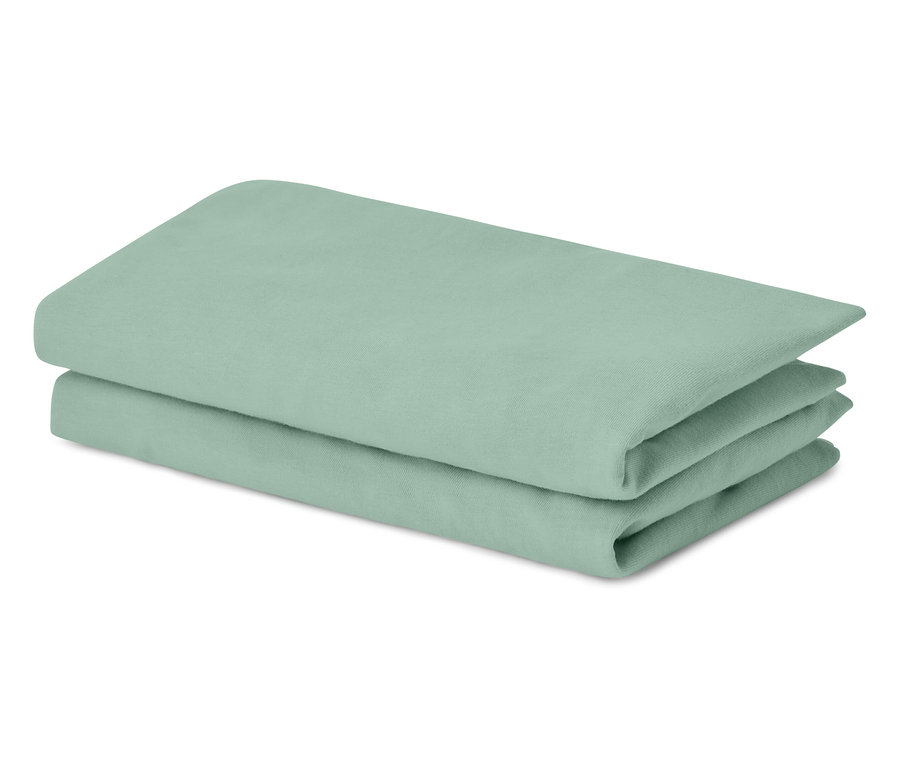 Linge de lit vert clair empilé.
