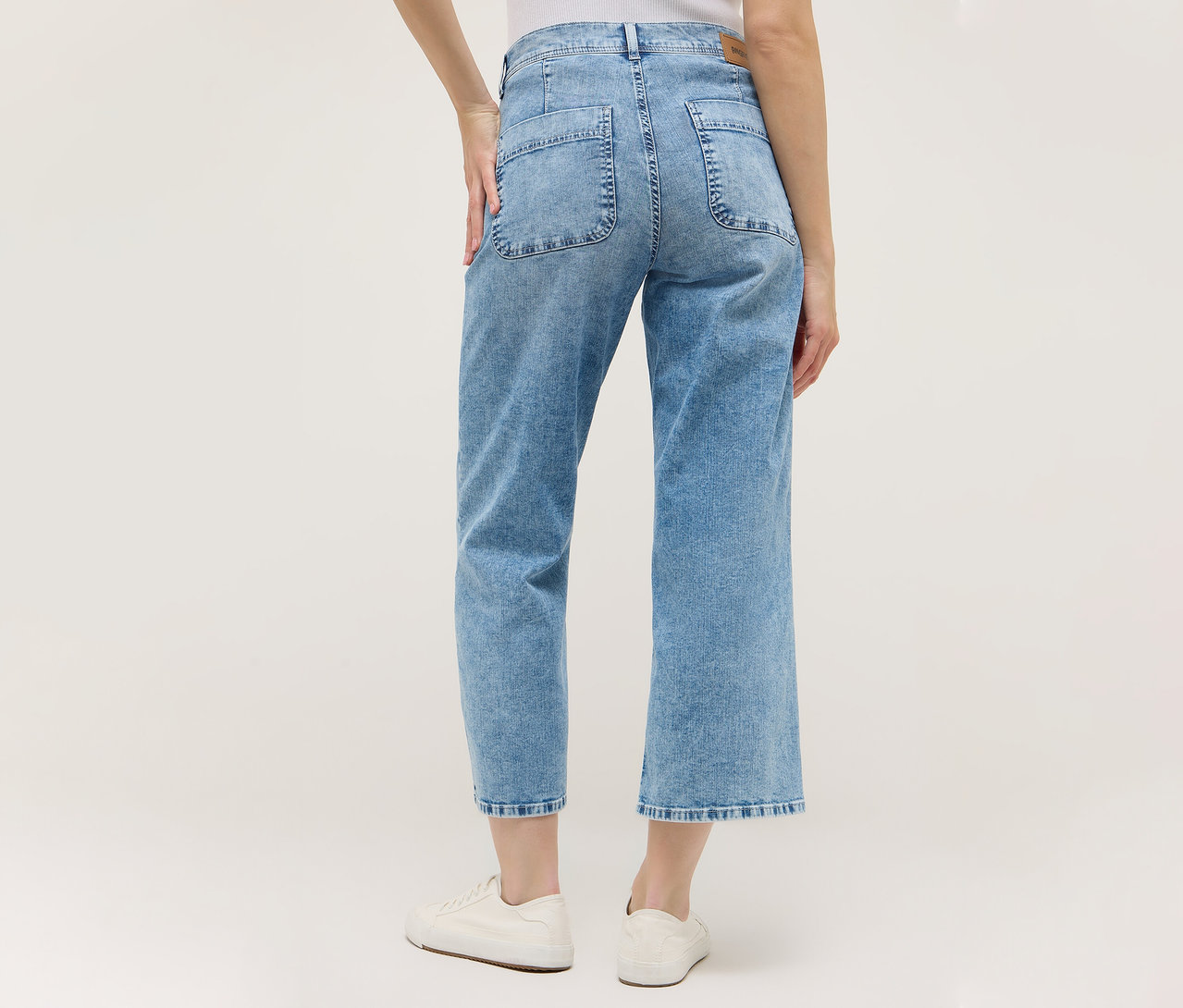 Vue arrière d'une femme portant une culotte Angels Denim «
Linn Smart
» bleu clair et des chaussures blanches.