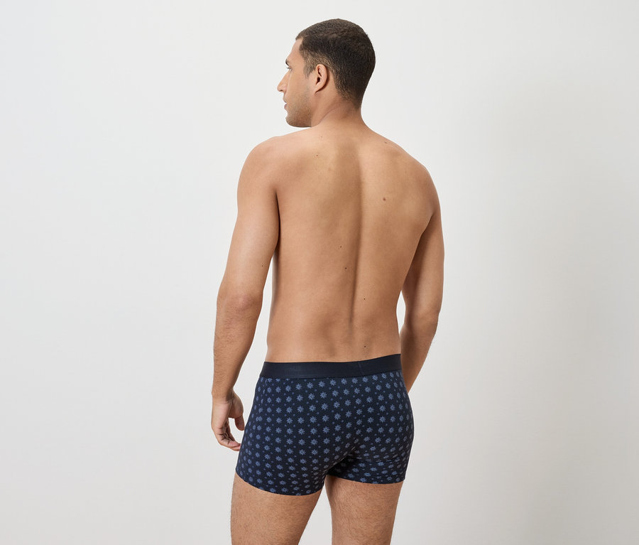 Vue arrière d'un homme portant un boxer bleu marine à pois.