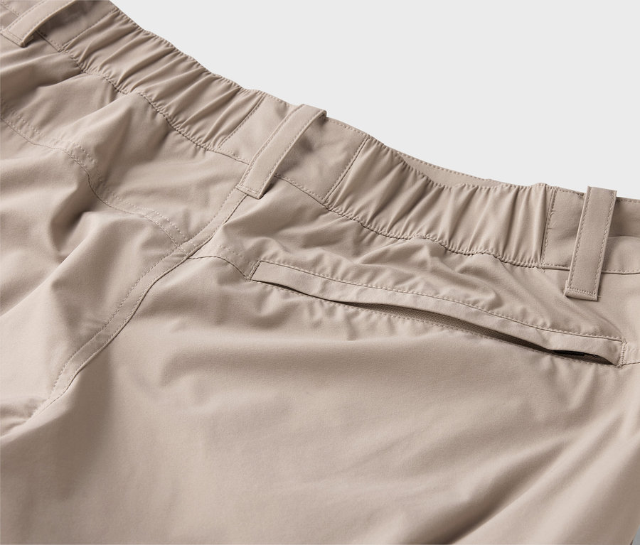 Gros plan d'un pantalon beige avec une ceinture élastique et des poches.