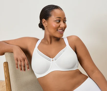 Femme assise sur une chaise portant un soutien-gorge blanc.