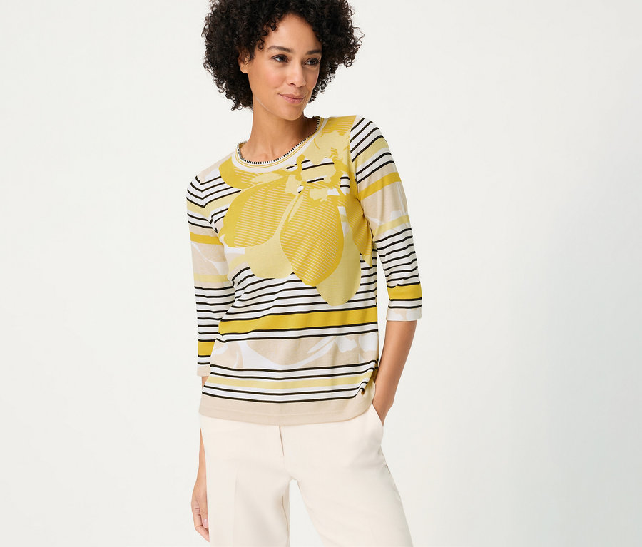 Femme portant un pantalon beige et un T-shirt 3/4 Olsen à rayures avec motif jaune.