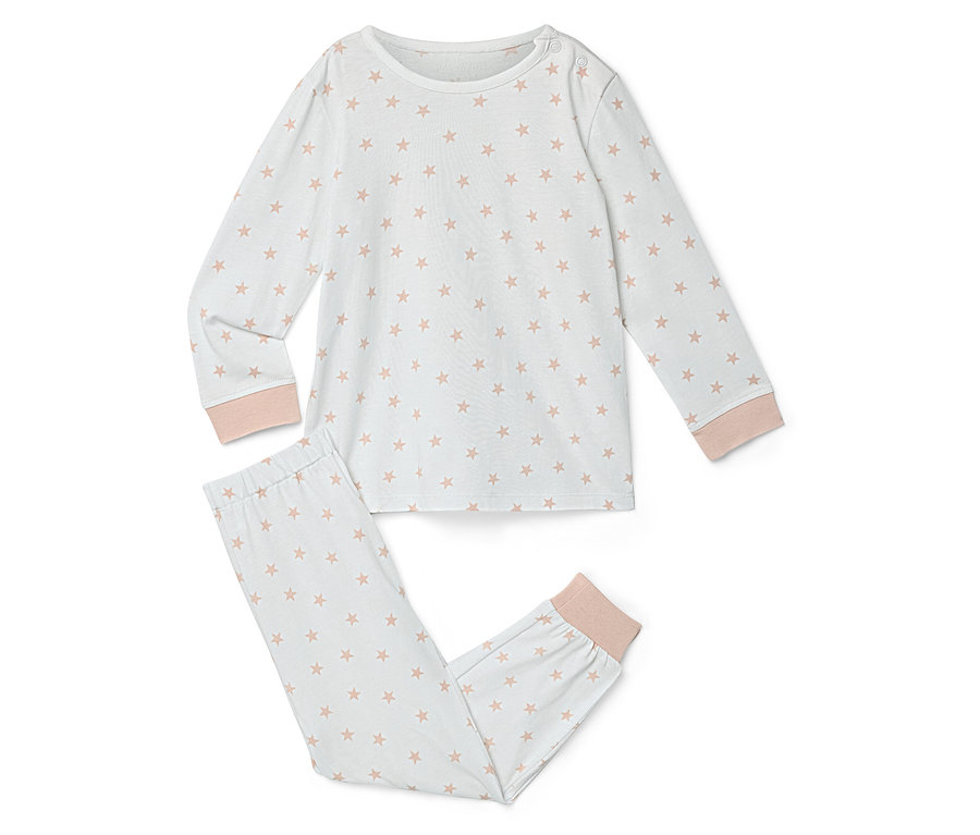 Un pyjama blanc avec un motif d'étoiles roses est posé sur un fond blanc.