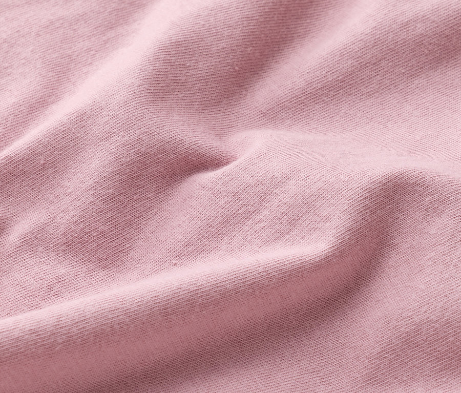 Gros plan de la texture d'un tissu rose clair.