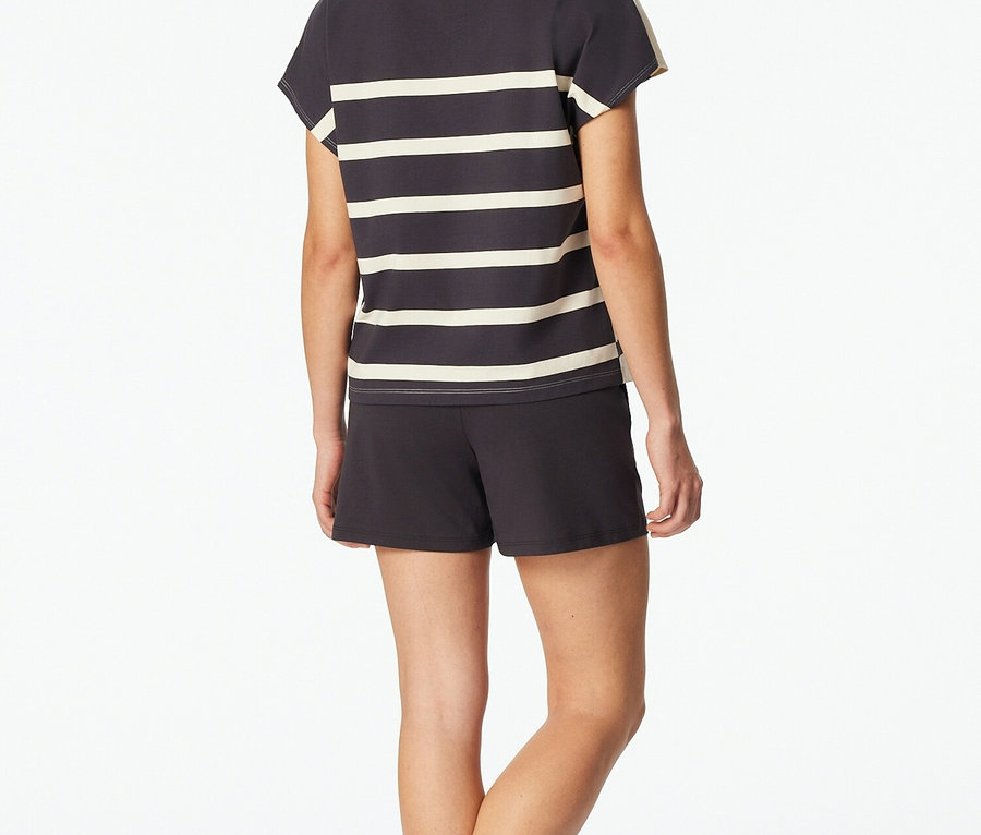 Femme vue de dos portant un t-shirt rayé gris et blanc et un short.