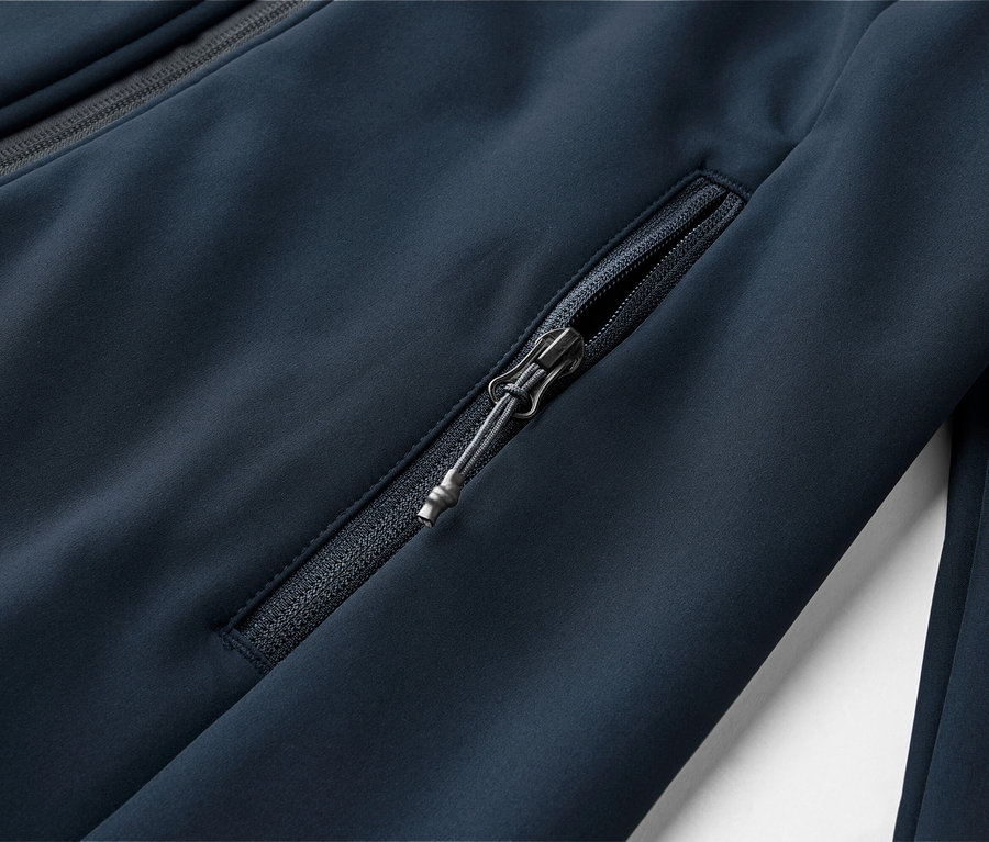 Gros plan d'une veste bleu marine avec une poche zippée et une fermeture éclair au niveau du col.