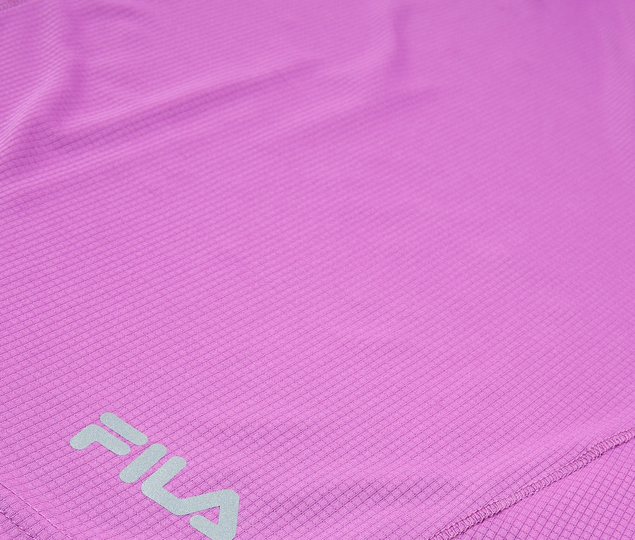 Gros plan d'un haut de sport Fila violet avec un motif carré répétitif.
