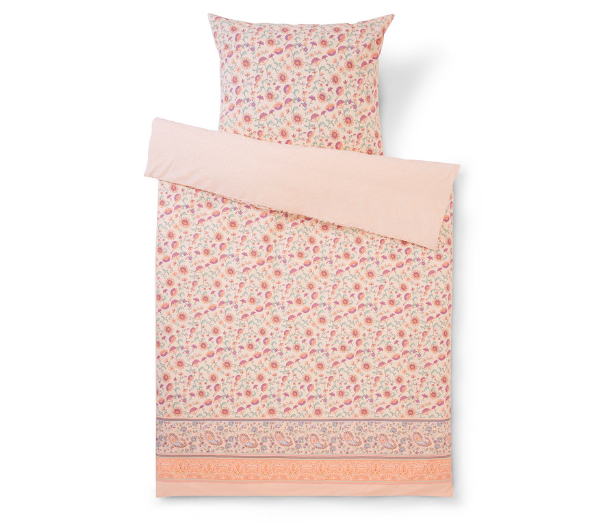 Ensemble de literie à motifs floraux avec une taie d'oreiller et une couette, toutes deux à motifs floraux roses et un dessus rose uni.