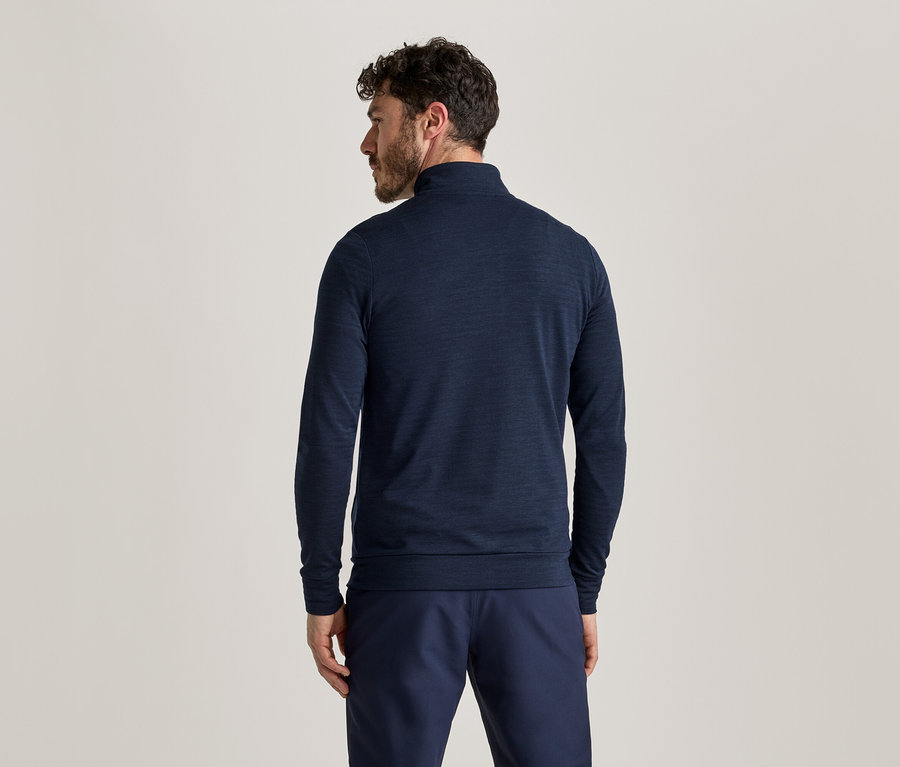 Vue de dos d'un homme aux cheveux foncés portant un T-shirt à manches longues bleu marine et un pantalon.