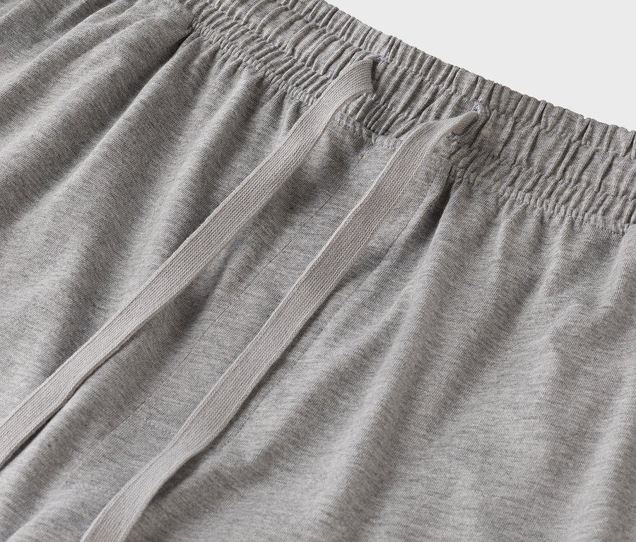 Gros plan sur un pantalon de jogging gris avec cordon de serrage.