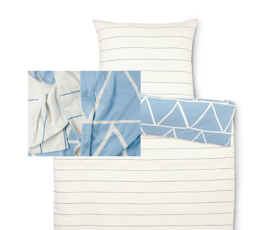 Ensemble de literie avec une housse rayée bleu et blanc et une taie d'oreiller à motifs triangulaires.