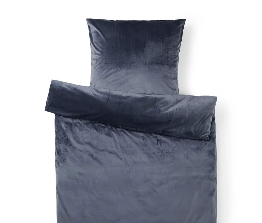 Parure de lit en velours bleu foncé/gris, composée d'une housse de couette partiellement pliée et d'une taie d'oreiller.