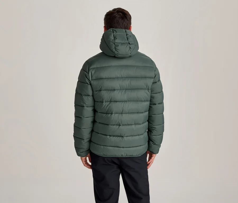 Personne de dos portant une doudoune à capuche vert foncé et un pantalon noir.