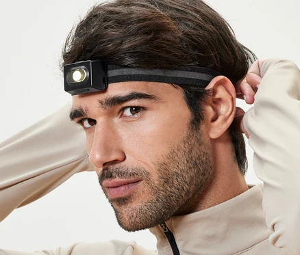 Un homme ajuste sa lampe frontale.