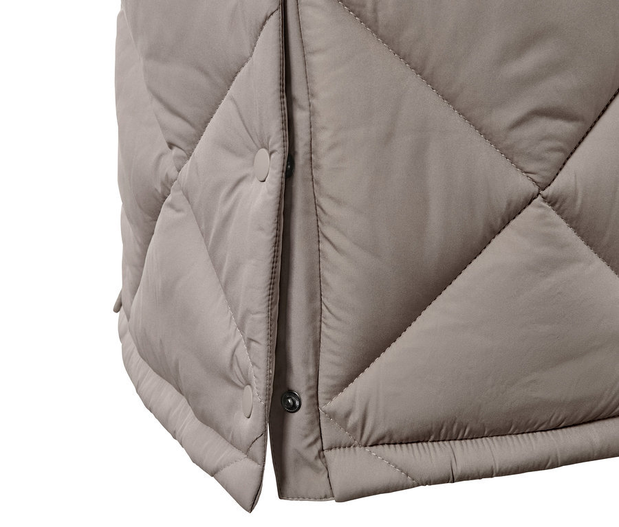Détail d'un long gilet matelassé avec capuche.