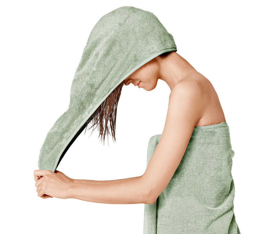 Femme séchant ses cheveux avec une serviette turban verte.
