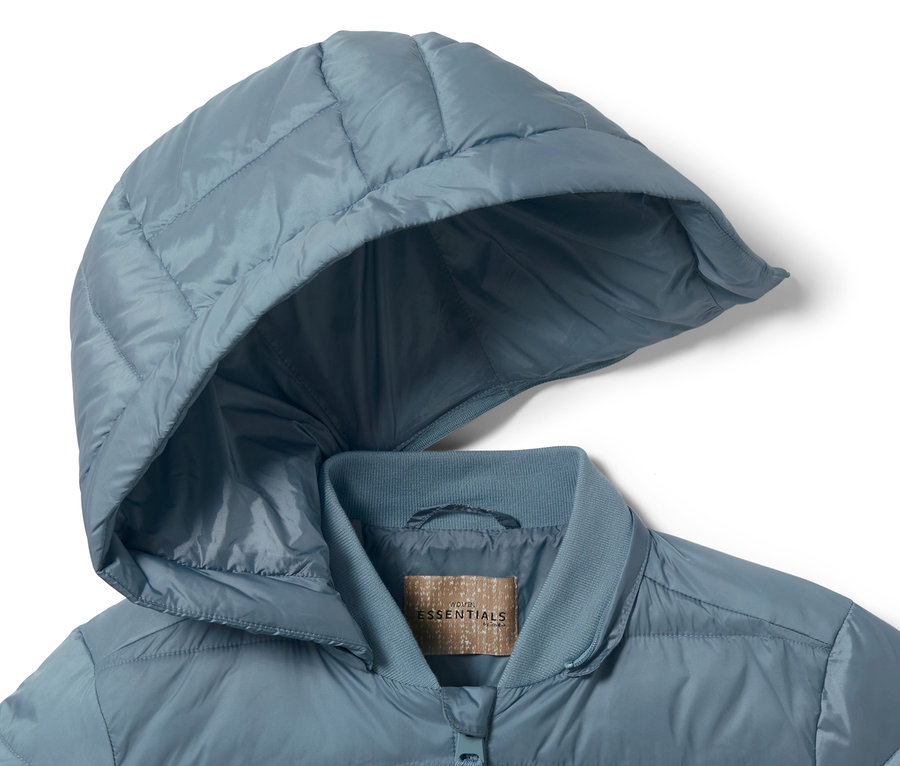 Gros plan sur une veste matelassée à capuche bleue.