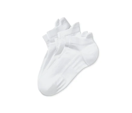 Gros plan de trois paires de chaussettes de course blanches unisexes.