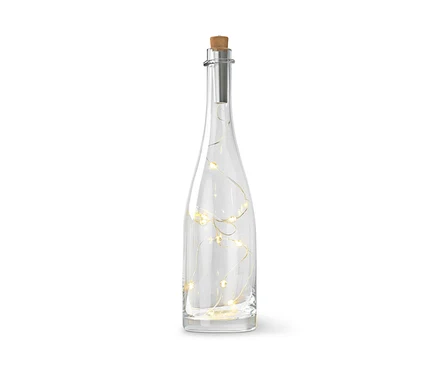 Une bouteille en verre transparent avec un bouchon de liège et une guirlande lumineuse à l'intérieur.