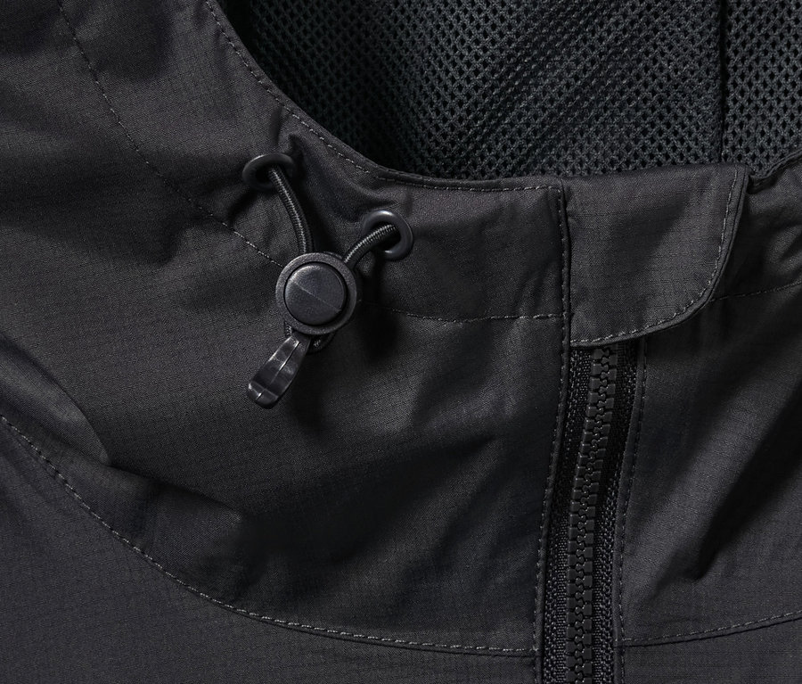 Gros plan sur une veste de pluie noire avec fermeture éclair et cordon de serrage à la capuche.