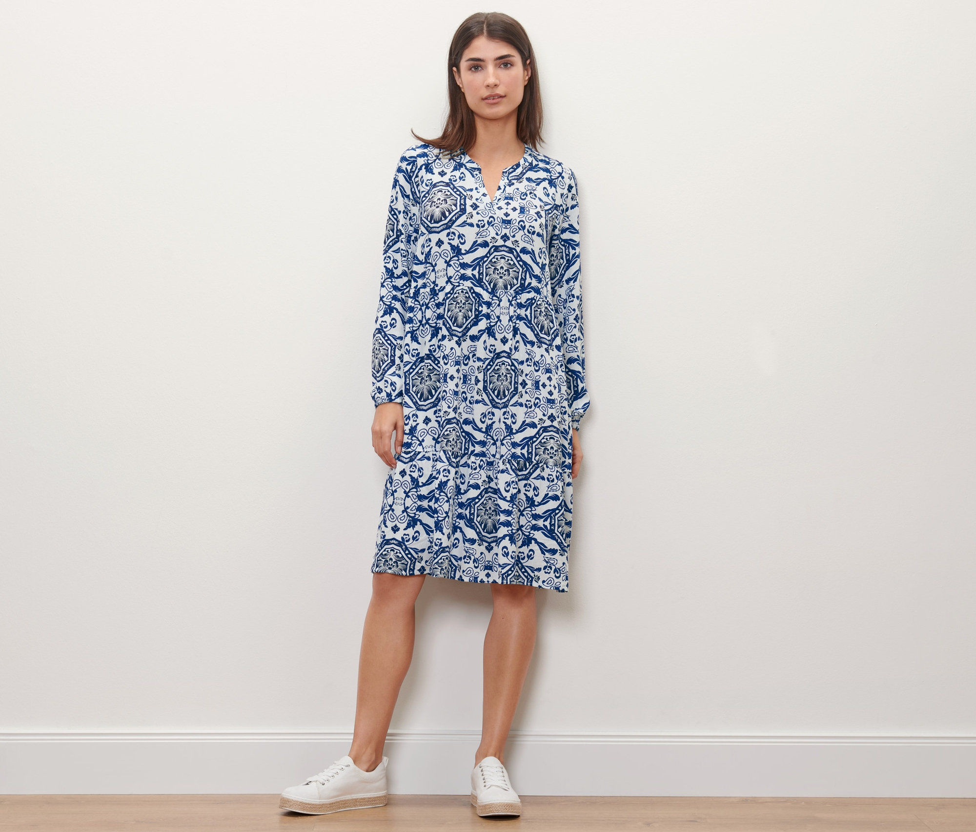 Femme posant dans une robe tissée imprimée bleue.