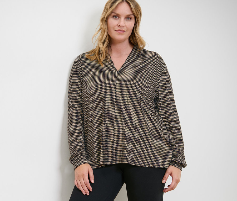 Femme posant en blouse imprimée avec encolure en V et legging heavy.