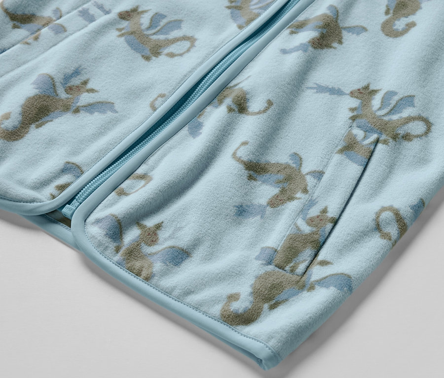 Détail d'une veste polaire pour enfant avec un motif de dragon.
