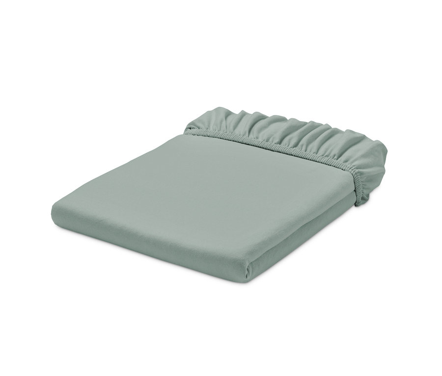 Un drap-housse en jersey vert sauge plié.