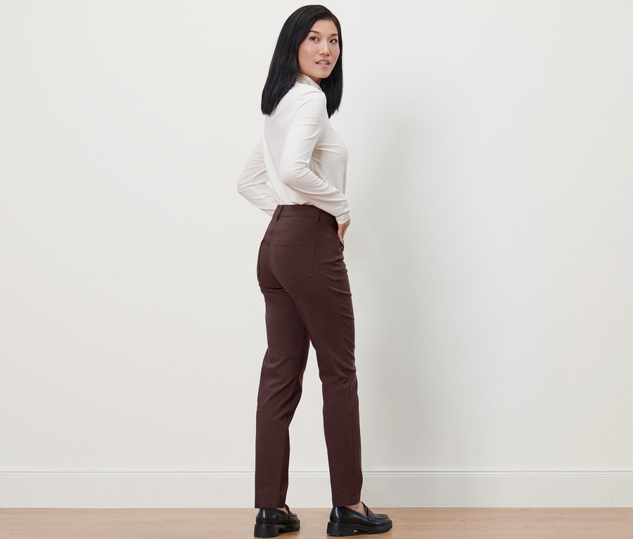 Femme posant en pantalon en bengaline marron et haut blanc.