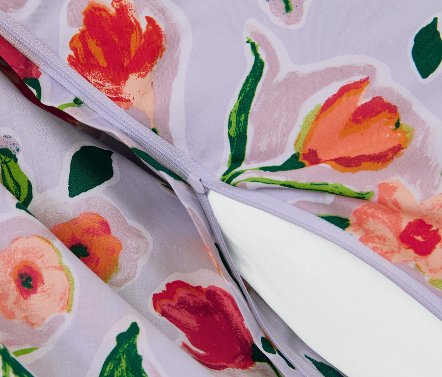 Gros plan d'une parure de lit en renforcé violet avec motif floral et fermeture éclair.