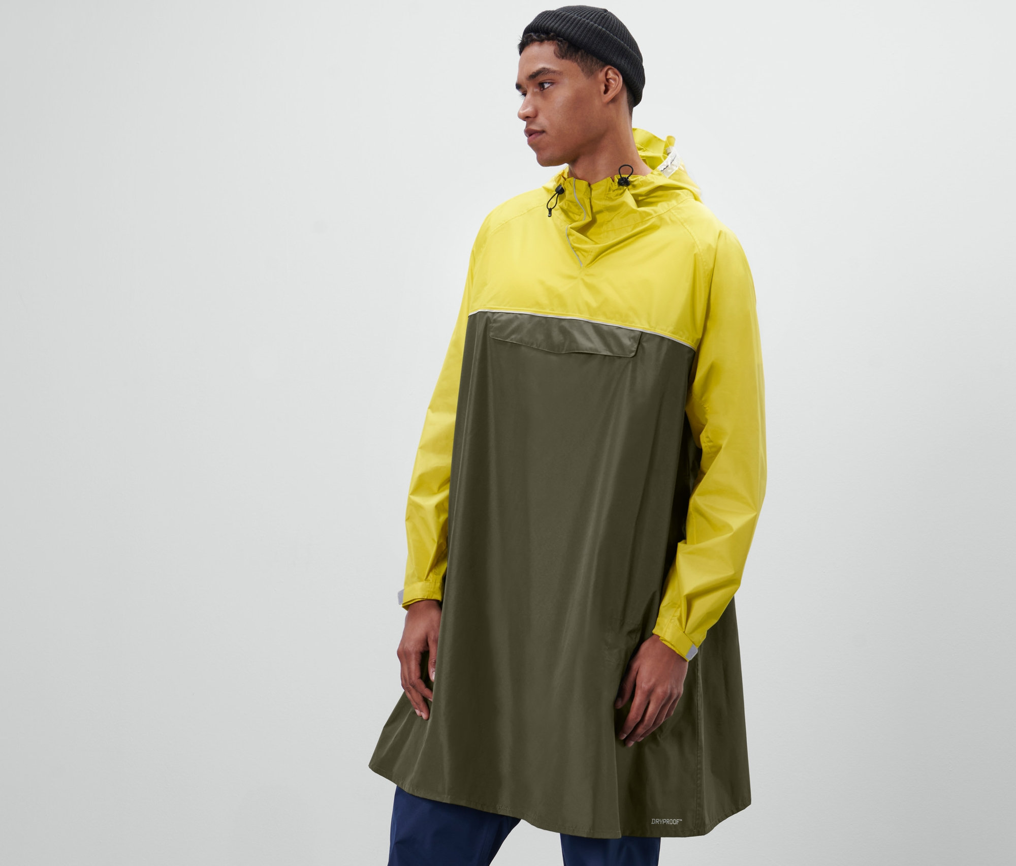 Un homme pose dans un poncho de pluie unisexe à manches.