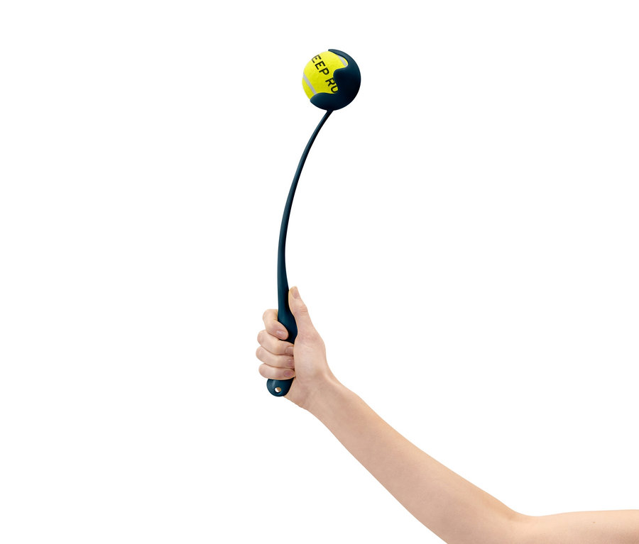 Une main tient un lanceur de balles bleu avec une balle de tennis jaune.