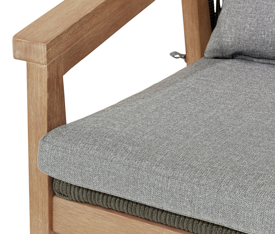 Gros plan d'un fauteuil de salon avec dossier arrondi et tressage textile, l'assise et le dossier sont gris.